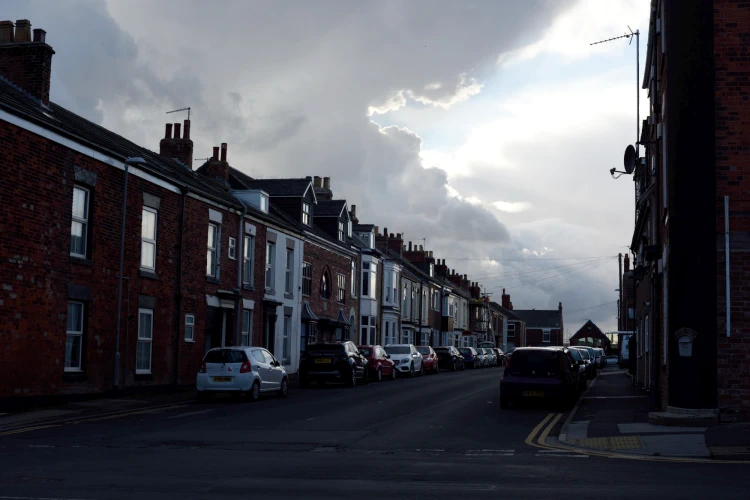 Terraced street with parked cars, in the dimming light of day